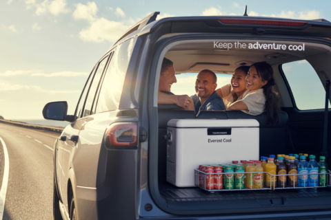 Friends enjoying a road trip with drinks stored in an Everest Cool unit, the best portable refrigerator for car adventures, keeping beverages cold and accessible in the vehicle trunk.