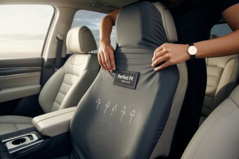 A person demonstrating how to use car seat cover by properly securing it over the seat for a snug and tailored fit inside a modern vehicle.
