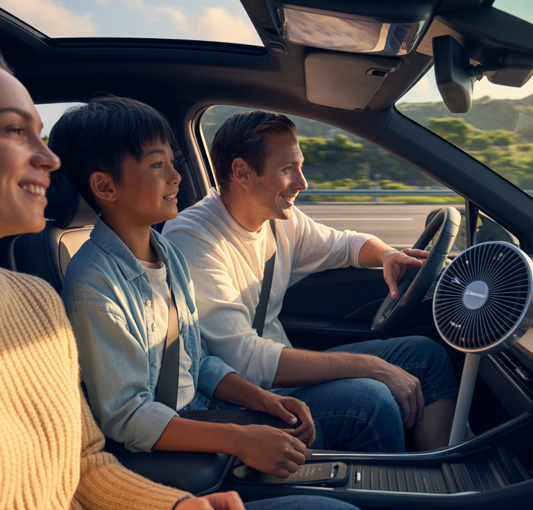 A family enjoying a comfortable ride with a Dashboard Solar Fan for Cars installed on the dashboard, providing eco-friendly cooling during summer travel.