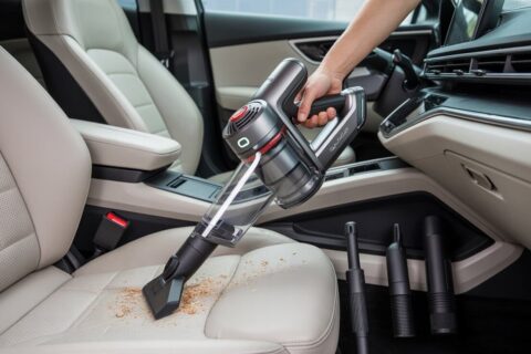 Best Affordable Vacuum Cleaner For Car​: Top 5 Under $100 in 2025 6 Person using the best affordable vacuum cleaner for car​ to clean crumbs from beige car seats.