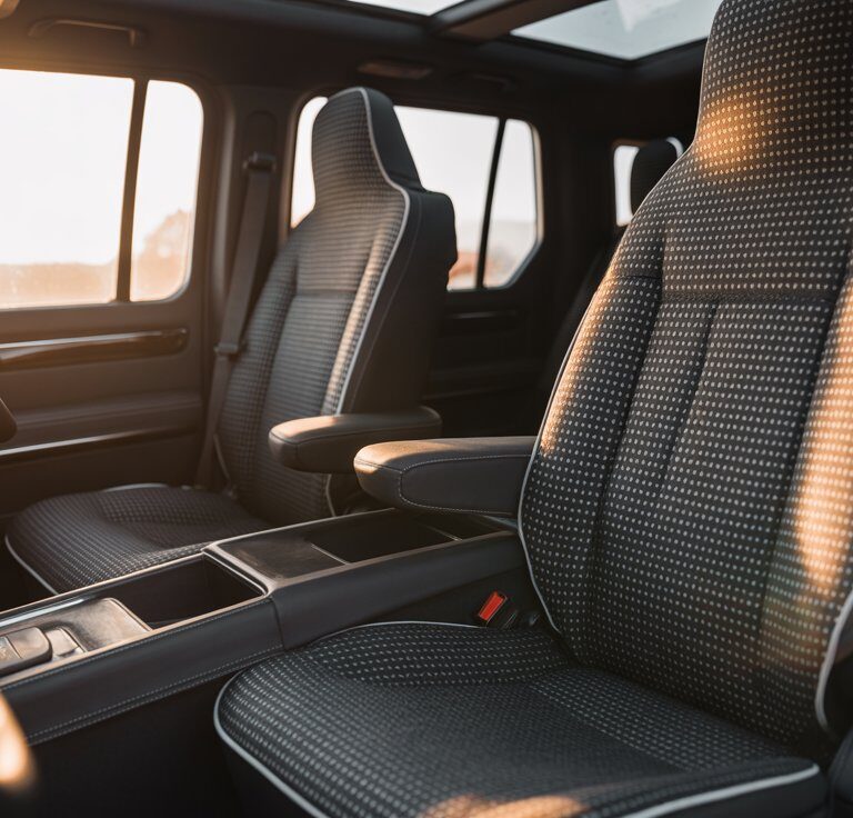 Modern SUV interior with black West Llama linen seat covers featuring triangular pattern for breathable comfort and universal protection.